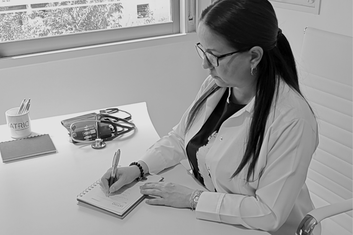 Médica de IATRIQ escribiendo en su escritorio